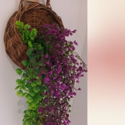ดอกไม้เลื้อยปลอมดอกไม้ประดิษฐ์ในตะกร้าสานแขวนผนัง Artificial climbing flowers in a woven wall basket.
