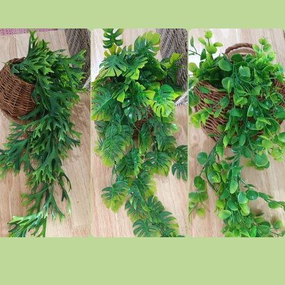 ต้นไม้เลื้อยปลอมประดิษฐ์ในตะกร้าหวายแขวนผนัง Artificial climbing plant in a wicker basket.