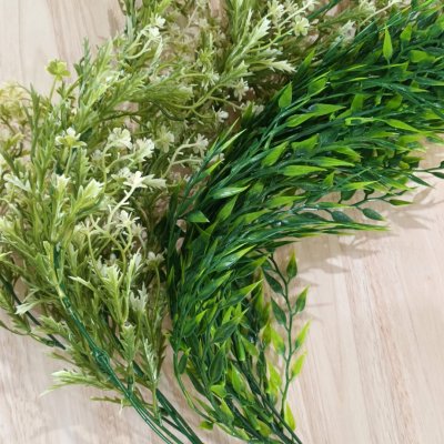 ดอกไม้เลื้อยปลอมสีขาวในตะกร้าสานแขวนผนัง Artificial white climbing flowers in a woven basket.