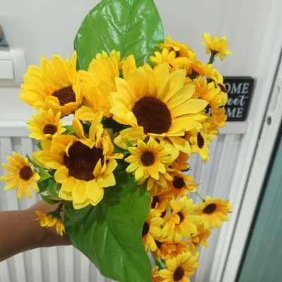อดอกทานตะวันปลอมประดิษฐ์แจกันแก้ว Artificial sunflowers in a glass vase.