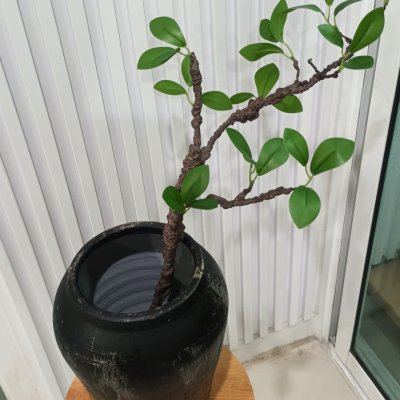 กิ่งไม้ใบไม้ปลอมประดิษฐ์ไหดินเผา Artificial branches and leaves in a clay pot.