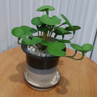 ต้นไม้ปลอมประดิษฐ์ขนาดเล็กในกระถางเซรามิก Small artificial plant in a ceramic pot.