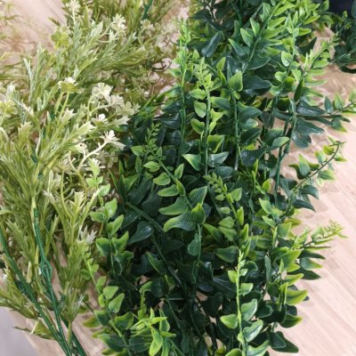 ดอกไม้เลื้อยปลอมสีขาวในตะกร้าสานแขวนผนัง Artificial white climbing flowers in a woven basket.