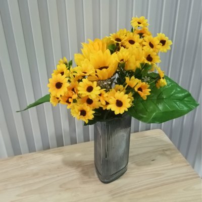 อดอกทานตะวันปลอมประดิษฐ์แจกันแก้ว Artificial sunflowers in a glass vase.