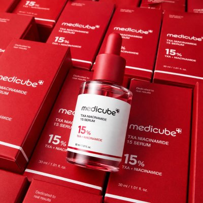 ภาพสินค้า Medicube TXA Niacinamide 15 Serum วางบนกล่องสีแดงจำนวนมาก สื่อถึงความพรีเมียมและความน่าเชื่อถือของแบรนด์สกินแคร์เกาหลี