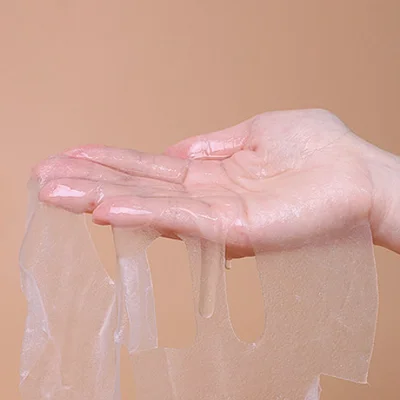 ภาพระยะใกล้ที่แสดงเนื้อสัมผัสของแผ่นมาสก์ Arocell Hyal B5 Water Gel Sheet ที่บางใส ชุ่มฉ่ำไปด้วยเอสเซนส์บนมือ