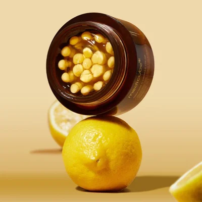 กระปุก Medicube Deep Vita C Capsule Cream วางบนลูกเลมอน สื่อถึงส่วนผสมของวิตามินซีเข้มข้นที่ช่วยลดฝ้า กระ