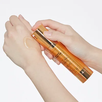 รูปมือกำลังกดเซรั่ม VT Vita-Light Reedle Shot 100 เนื้อเซรั่มสีทองลงบนผิว แสดงการใช้งานจริง