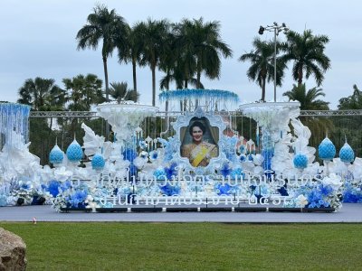 ซุ้มพิธีการงานกาชาดประจำปี 2568 ตกแต่งด้วยดอกไม้โทนสีฟ้าและขาว จัดวางอย่างสุภาพตามรูปแบบพิธีการกลางแจ้ง