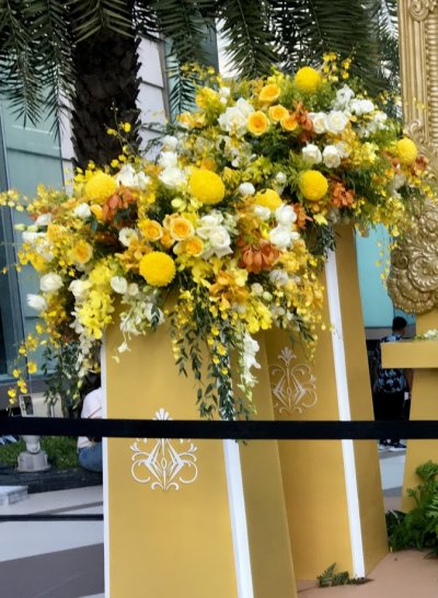 ซุ้มเฉลิมพระเกียรติพระบาทสมเด็จพระบรมชนกาธิเบศร มหาภูมิพลอดุลยเดชมหาราช บรมนาถบพิตร  ภายนอกอาคาร Siam Paragon  สวยงามด้วยโครงสร้างสีทองและดอกไม้โทนเหลืองทอง, ผู้รับเหมางานจัดซุ้มถวายความเคารพ, ช่างจัดดอกไม้งานพิธีการนอกสถานที่, บริการดอกไม้งานเฉลิมพระเกีย