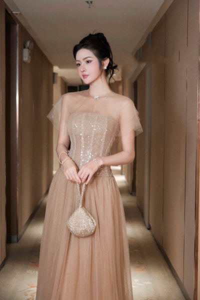 เดรสยาวสีเบจมีตกแต่งลูกปัดแวววาวมีผ้าซีทรูคลุมไหล่หรูหรา