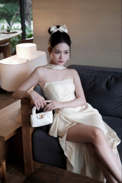 เดรสยาวสีครีมแบบเกาะอกผ่าข้าง ตกแต่งเข็มกลัดดอกไม้สีทอง