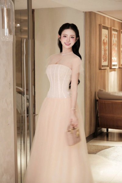 เดรสยาวสีชมพูเกาะอกตกแต่งผ้าซีทรูที่ไหล่และโบว์คริสตัล