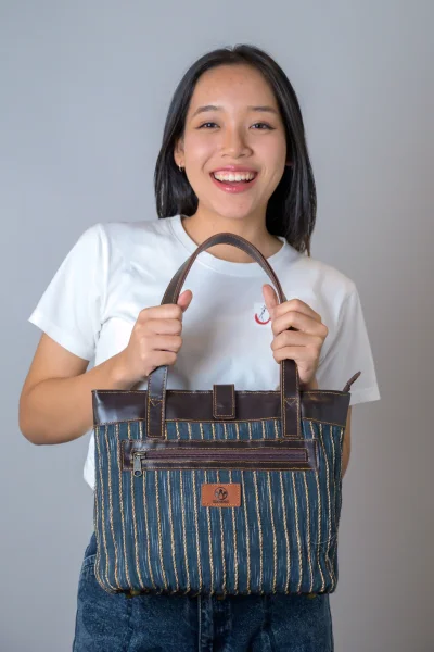 กระเป๋าสะพายสายหนัง ฝ้ายย้อมครามผสานเส้นผักตบชวา Indigo-dyed cotton shoulder bag with leather straps  and water hyacinth fibers.