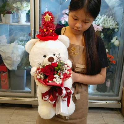 หมีสีขาวหมวกแดงอุ้มดอกไม้