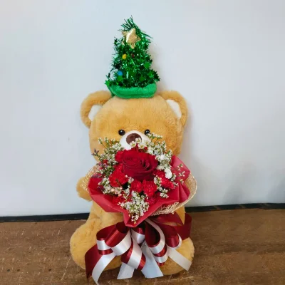 หมีสีน้ำตาลหมวกเขียวอุ้มดอกไม้