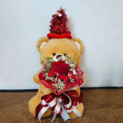 หมีสีน้ำตาลหมวกแดงอุ้มดอกไม้