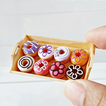 Miniature donuts in assorted designs, perfect for 1:12 scale dollhouse kitchens or bakery displays, handcrafted polymer clay food decor.