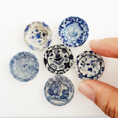 Set of six miniature 2.5 cm ceramic plates with intricate blue and white designs, perfect for dollhouse decor or collectible displays.