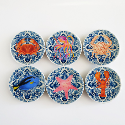 Miniature ceramic plates with nautical and sea life designs, ideal for coastal dollhouse decor or as collectible miniatures.