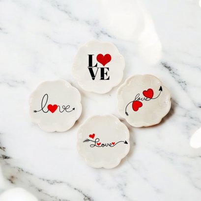 Set of four miniature ceramic plates with love-themed designs, featuring hearts and 'Love' text, perfect for dollhouse Valentine's decor.
