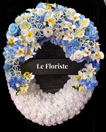 พวงมาลาดอกไม้สด ดอกไม้ประดิษฐ์ แบบ Modern-Thaiไทยจาก Le Floriste ออกแบบประณีตด้วยดอกไม้คุณภาพดีในโทนฟ้า&ndash;ครีม เพิ่มความงดงาม สง่างาม และเหมาะสมสำหรับการไว้อาลัยในพิธีสำคัญ เหมาะสำหรับองค์กรและบุคคลที่ต้องการแสดงความเคารพอย่างสมเกียรติ พร้อมบริการจัดส่งถึงง