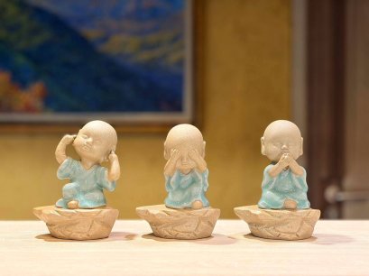 Three ceramic novice monk statues
