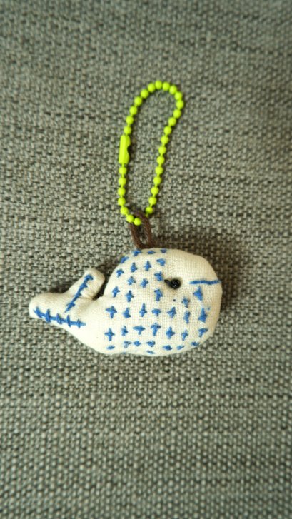 white cloth keychain, green cord