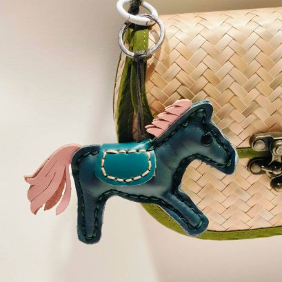 Green horse keychain with a pink tail