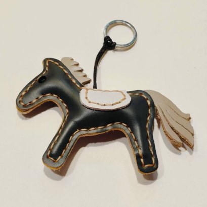 Black horse keychain with a gray tail