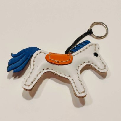 White horse keychain with a blue tail