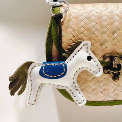 White horse keychain with a light blue tail