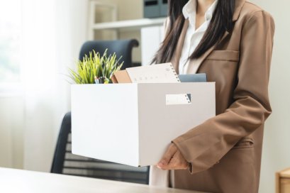 ผู้หญิงเก็บของจากโต๊ะทำงานหลังโดนเลย์ออฟจากบริษัท