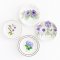 Miniature ceramic decorative plates featuring intricate purple floral designs, perfect for dollhouse kitchens, collectibles, and elegant tiny decor.