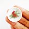 Miniature Christmas plates with cardinal designs, perfect for dollhouse holiday decor and adding festive cheer to miniature scenes.