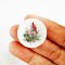 Miniature Christmas plates with cardinal designs, perfect for dollhouse holiday decor and adding festive cheer to miniature scenes.