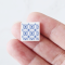 Set of 16 miniature ceramic tiles featuring a bold blue geometric floral pattern. Perfect for 1:12 scale dollhouse decor.