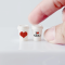 Set of two miniature coffee cups with love-themed designs, featuring 'I ❤️ YOU' and a heart, perfect for Valentine's Day dollhouse decor