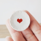 Close-up of miniature ceramic plates with heart motifs, ideal for dollhouse table settings or Valentine's Day themes.