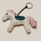 White horse keychain with a pink tail