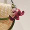 Red baby elephant keychain with a brown saddle